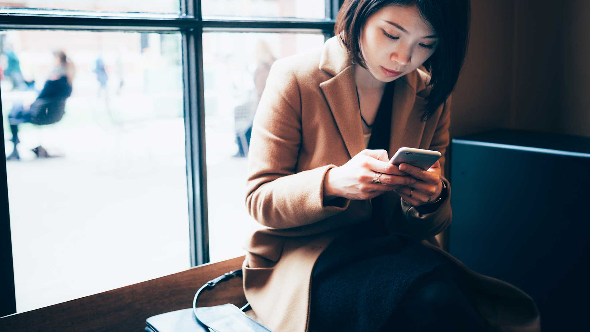 A female checking phone,image is used for HSBC China WeChat Service Account