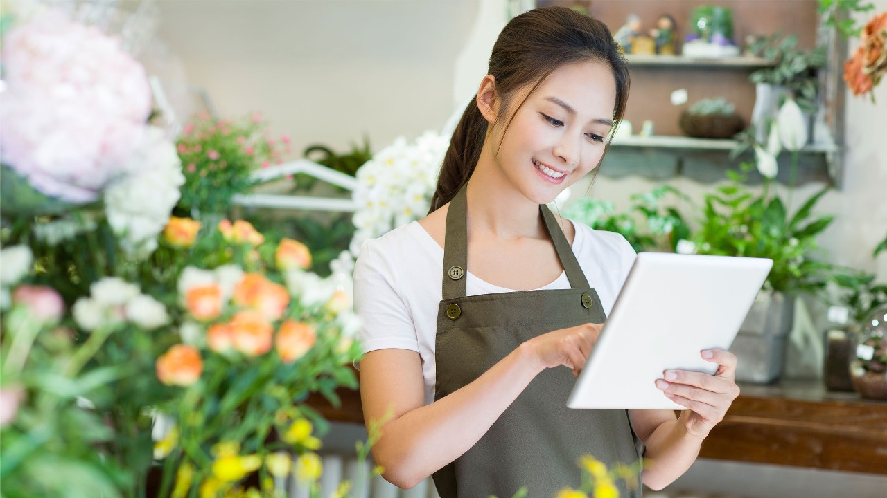 Florist employee looking at tablet，image used for help and support