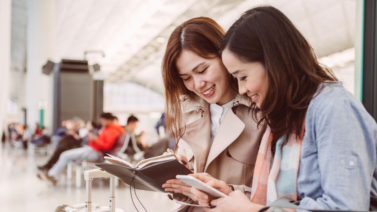 two girls wacth book , image is used for travel insurance