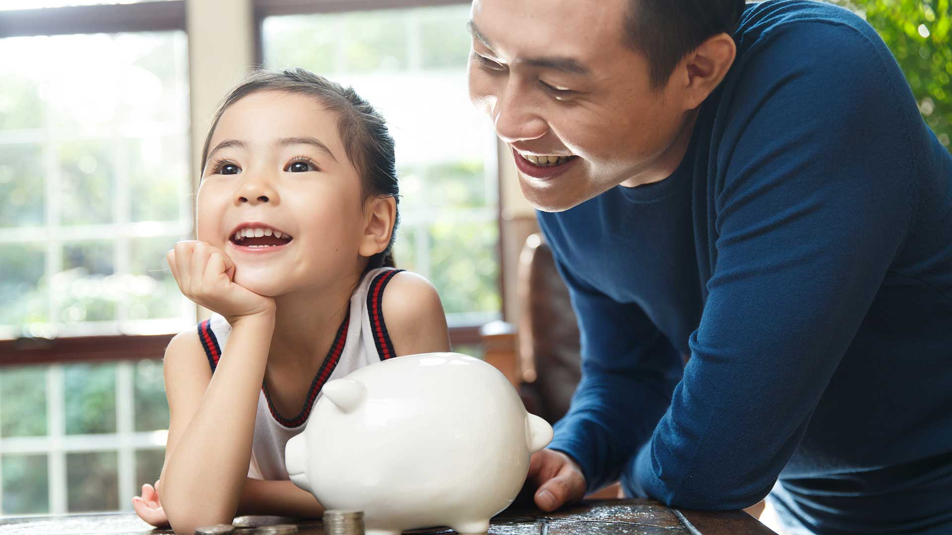 father ,daughter and piggy bank; the image used for wealth education
