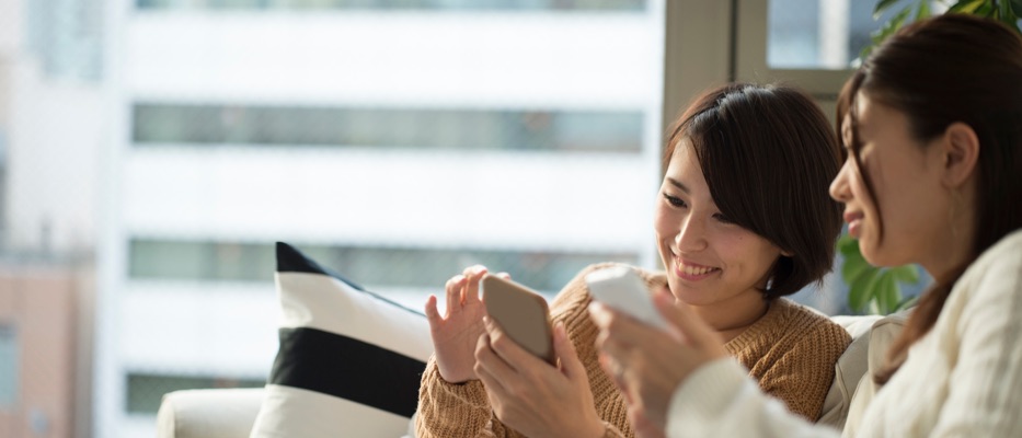 两位女士在看手机；图片用于汇丰留学助手微信小程序