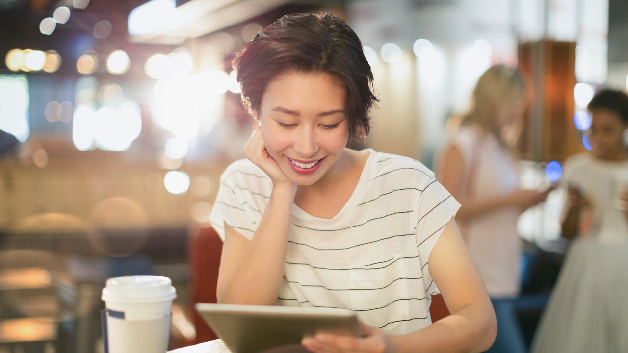 女孩微笑着看电脑;图片用于星巴克30元券