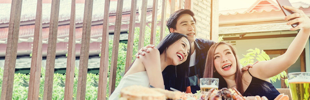 聚会时欢笑自拍的人们；图片用于汇丰生活信用卡