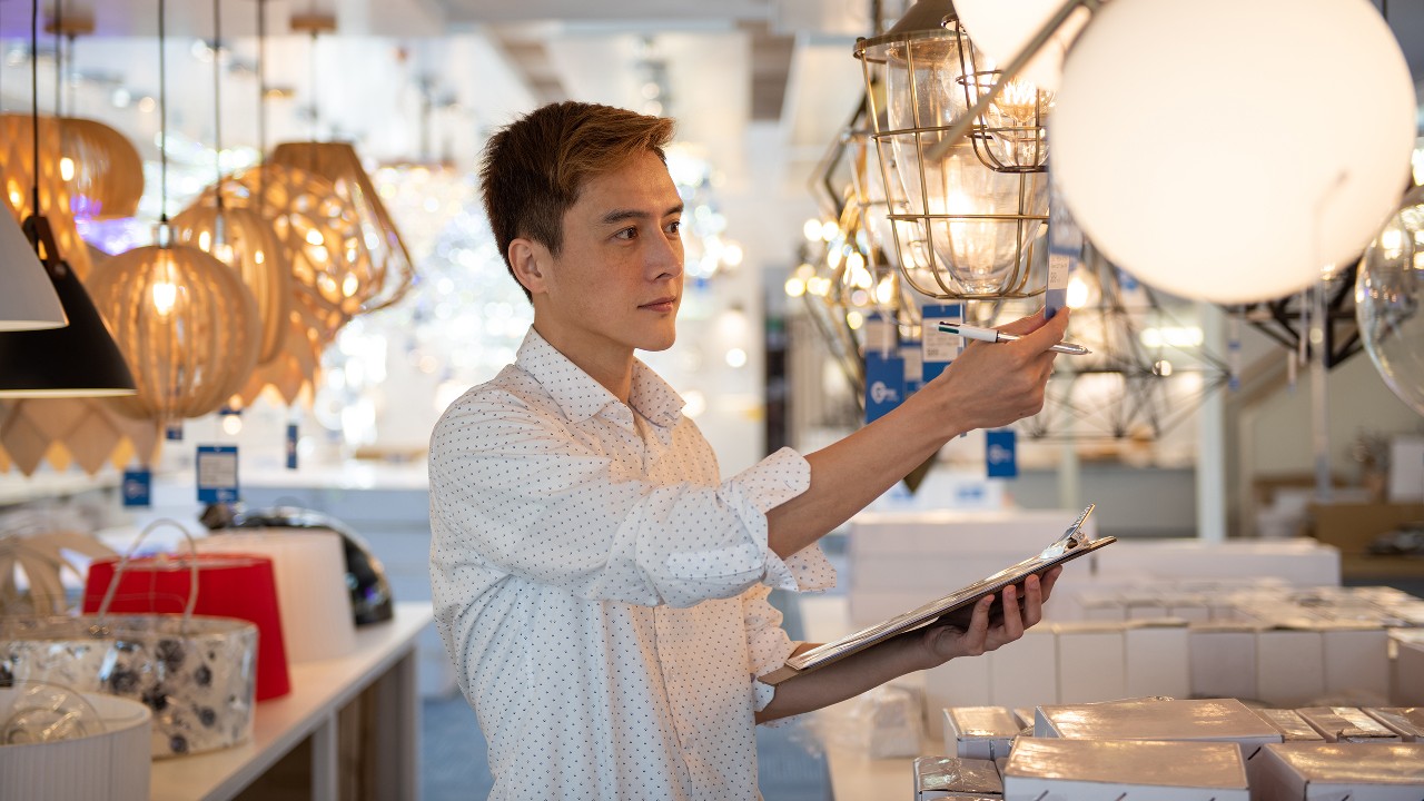 一名灯具店小企业主正在处理店务；图片使用于汇丰汇融汇立业融齐家—零售中坚力页面。