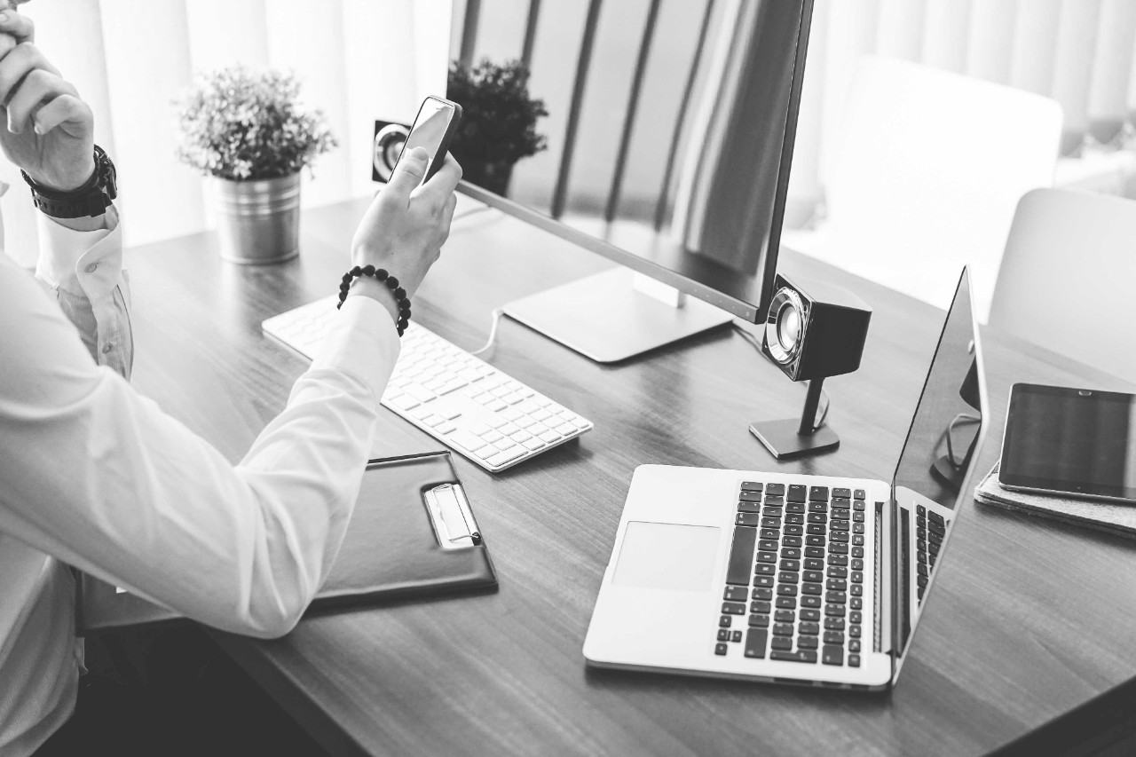 A person using mobile phone in office; image used for Knowledge Centre page.