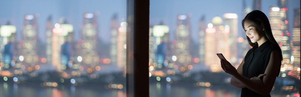 woman looking at night scenery of city; used for HSBC in greater China