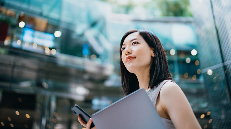 woman uses laptop and mobile; the image used for Local Unit Trust (Third Party)