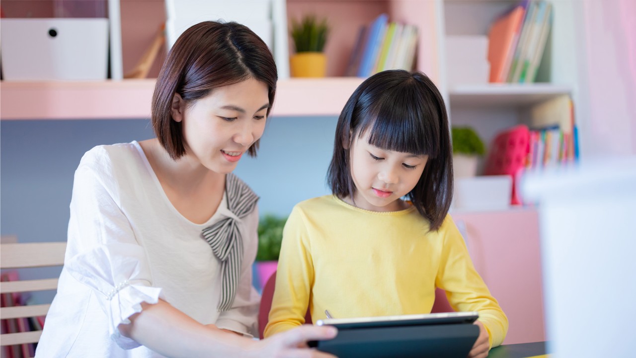 Mother and daughter looking at the tablet; the image used for getting into a savings habit