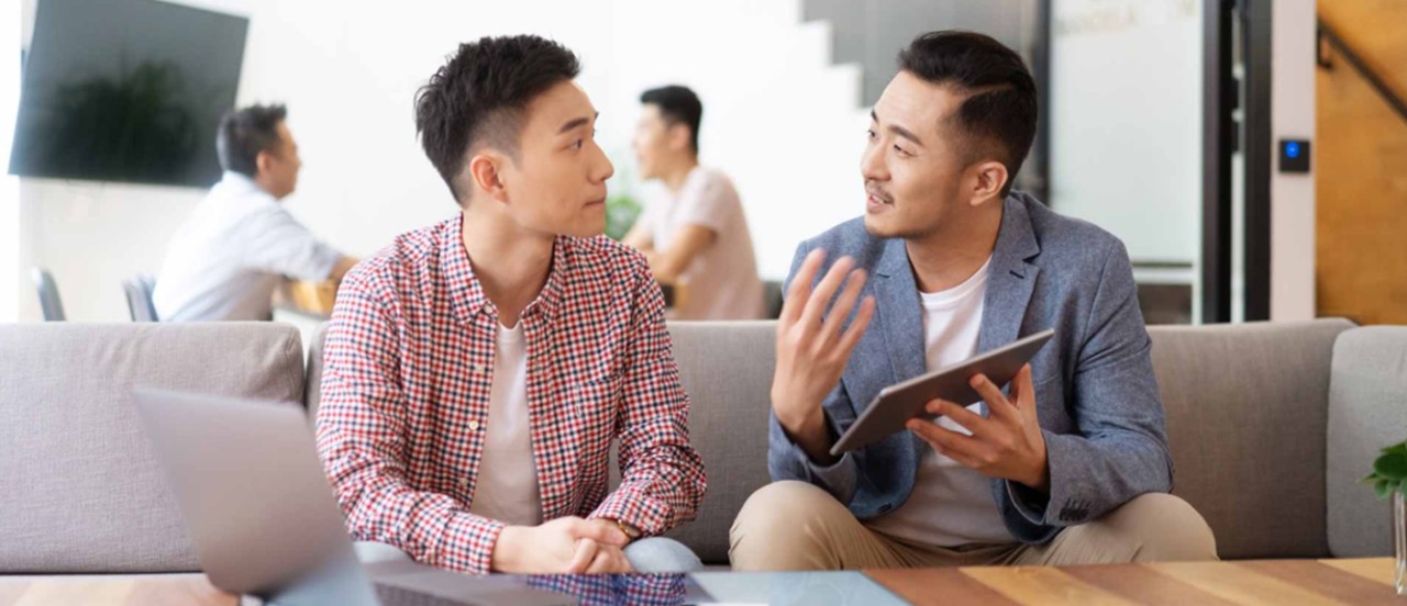 在公司与同事交谈的实习生