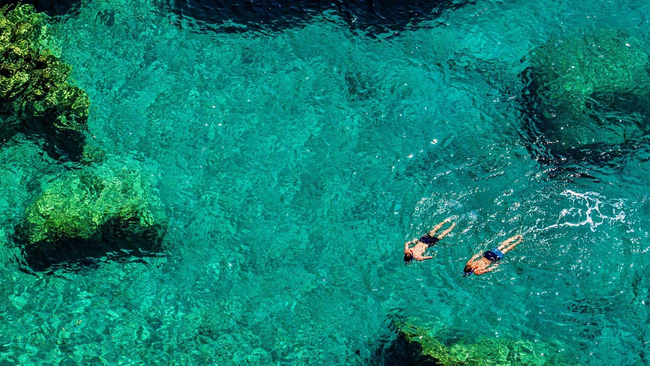 Two people swimming in the sea; image used for wealth management