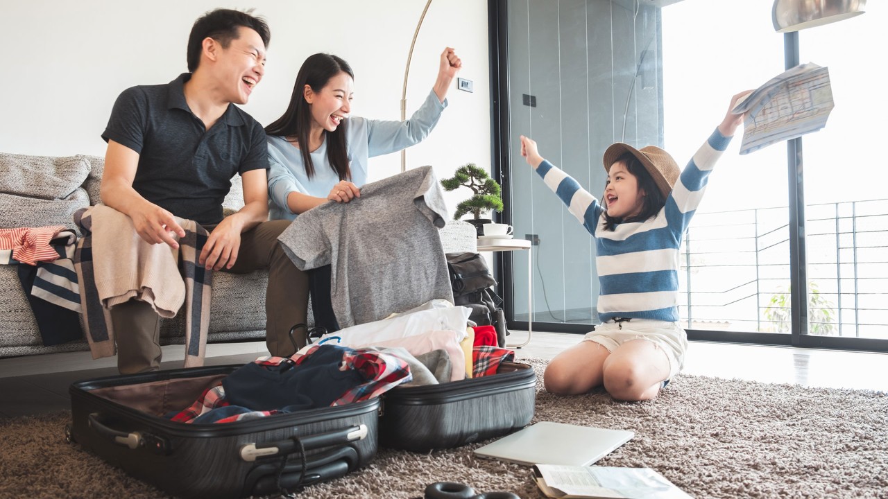 Parents and daughter packing up luggage, ready to travel