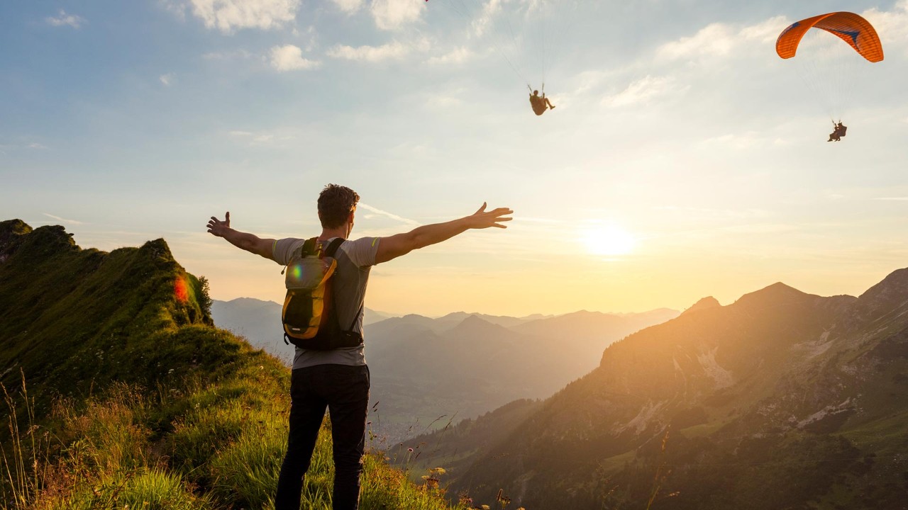 Man with open arms on the mountain peak