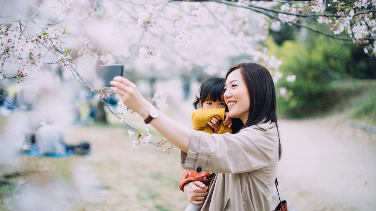 妈妈抱着女儿赏花；图片用于大都会人寿都会臻传终身寿险（分红型)