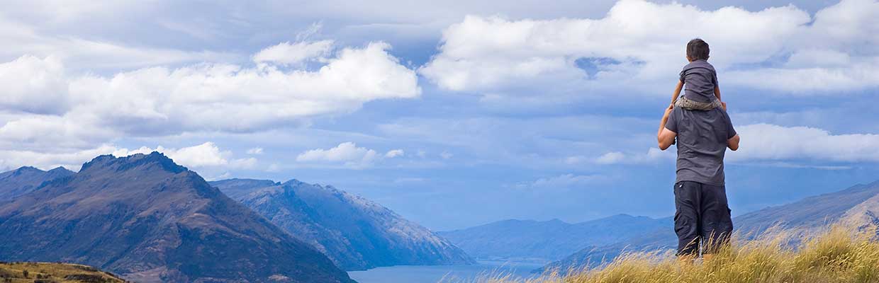 Father and son look out on the top of the mountain，image is used for deposits