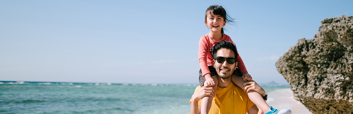 Little girl sitting on dad's shoulders; image used for relocating overseas