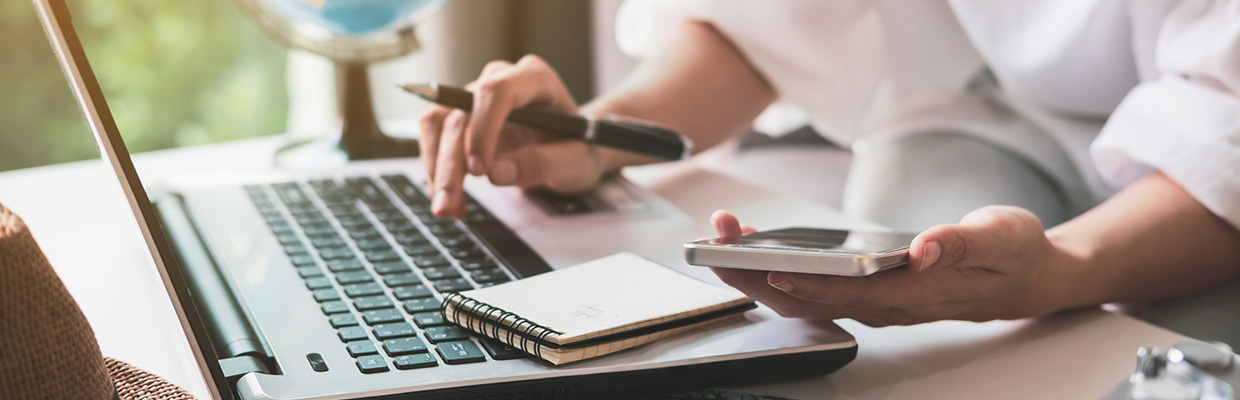 People who check information with computer and phone; the image used for creating a budget