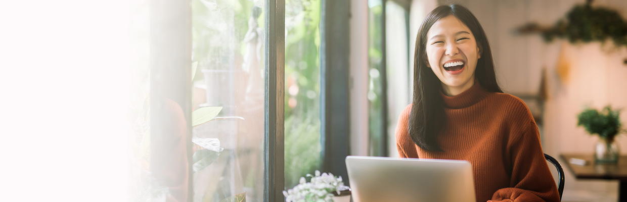 the smiling girl before the laptop, the image used for Foreign currency solutions